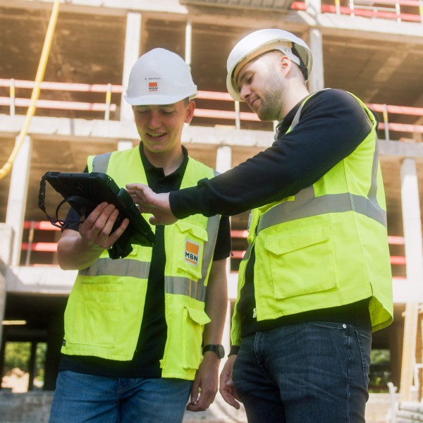 Mitarbeiter von specter zeigt einem Bauleiter die Baustellenmanagement Software.